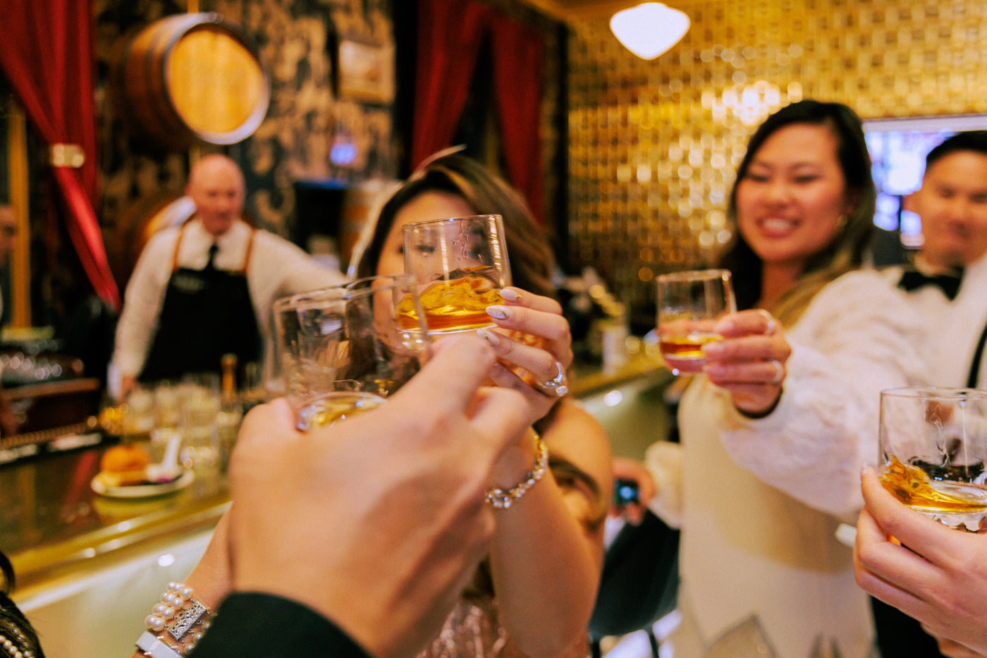 Guests toasting whiskey cocktails at Gold Bar Distillery in San Francisco, a popular venue for private events, group bookings, and cocktail classes on Treasure Island.